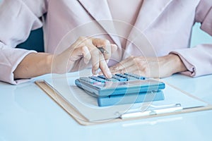 Asia business woman analyzing investment charts on desk.