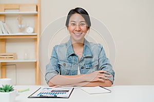 Asia business woman feeling happy smiling and looking to camera while relax at home office. Young asian woman working writing