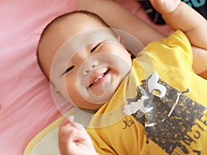 Asia Chinese adorable naughty cute toddler infant baby boy son smile grin lying on bed sunny day in Summer maternal love family