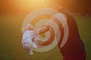 Asia Chinese happy Dad hug hold new-born chubby baby son in park forest outdoor in summer love peace smile bathed in sun portrait