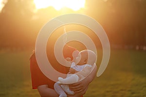 Asia Chinese happy mom hug hold kiss new-born chubby baby park forest outdoor in summer love peace smile bathed in sun portrait