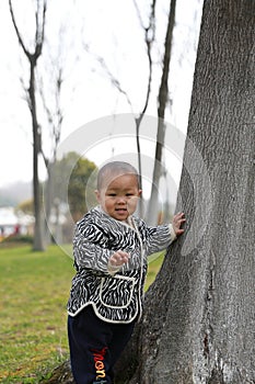 Asia Chinese little baby toddler boy child play hide and seek with his mom mother outdoor sunny happy smile carefree flower meadow