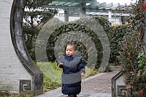 Asia Chinese little baby toddler boy child play outdoor in park forest sunny happy smile carefree flower meadow garden arched door