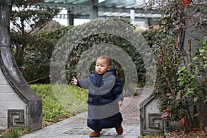 Asia Chinese little baby toddler boy child play outdoor in park forest sunny happy smile carefree flower meadow garden arched door