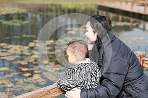 Asia Chinese Mom Mother and son maternal love hug embrace play outdoor in park pond bridge winter sunny day happy smile carefree