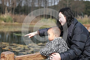 Asia Chinese Mom Mother and son maternal love hug embrace play outdoor in park pond bridge winter sunny day happy smile carefree