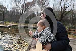 Asia Chinese Mom Mother and son maternal love hug embrace play outdoor in park pond bridge winter sunny day happy smile carefree