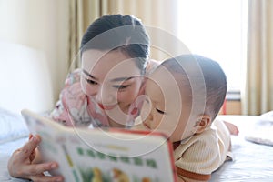 Asia Chinese Mom toddler baby boy son read book indoor home teaching early education lying on bed maternal love family