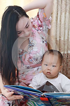 Asia Chinese Mom toddler baby boy son read book indoor home teaching sunny day in Summer early education maternal love family