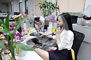 Asia Chinese office lady woman girl on chair make a call use desk phone chat work smile wear business occupation suit workplace