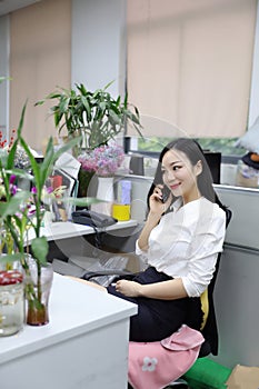 Asia Chinese office lady woman girl on chair make a call use desk phone chat work smile wear business occupation suit workplace