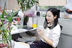 Asia Chinese office lady woman girl on chair thinking drink tea work laptop computer smile wear business occupation suit workplace