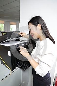 Asia Chinese office lady woman girl print copy paper use printer copier at work smile wear business occupation suit workplace