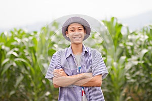 Asia farmer standing in middle corn fields and smiling face