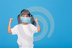 Asia girl wearing mask to protect against Coronavirus, girl show a fist encourage to fight contagious disease concept stop virus