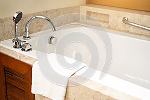 Asia hotel classic luxury bath with bath tub, faucet and white towel on white ceramic in a retro style