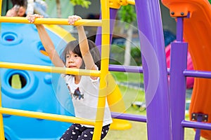 Asia kid girl having fun to play on children`s climbing toy at school playground,back to school outdoor activity