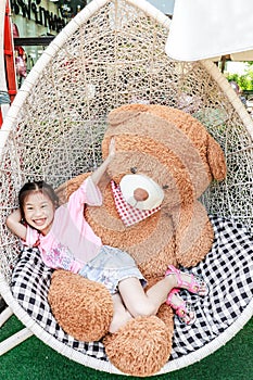 Asia little girl and big doll bear