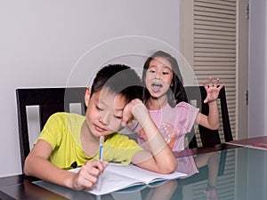 Asia little sister ridicule her brother studying and doing his h