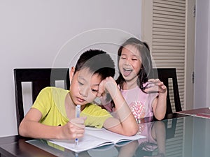 Asia little sister ridicule her brother studying and doing his h