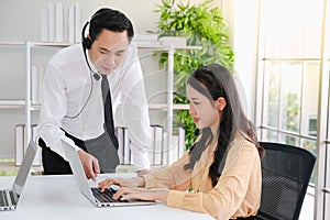 asia man and beautiful asian woman working call center operator with headset in office or workplace