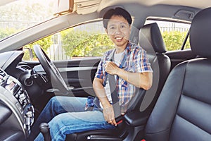 Asia man fastening seat belt in car