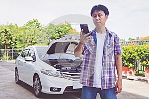 Asia man stand front a broken car calling for assistance