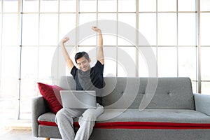 Asia man stretch oneself lazily while working with laptop