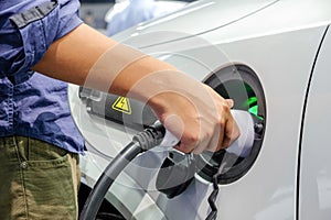 Asia men hands who are fueling a new vehicle electrification via rechargeable electricity machine