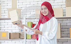 Asia Muslim businesswoman, SME owners inspect products in stock.