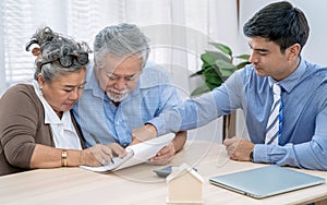 Asia senior couple making sign contract to buy new house.