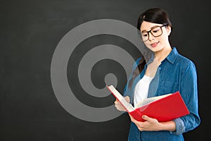 Asia student reading her work standing in front of blackboard