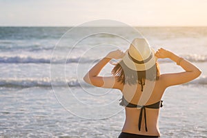 Asia woman with hat and bikini on sea beach