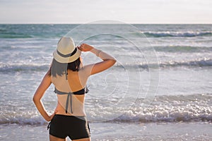 Asia woman with hat and bikini on sea beach