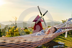 Asia woman relaxing in hammock at mornig time, Selective focus photo