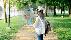 Asia woman traveler with backpack checks map to find directions in temple area, real explorer. Travel Concept