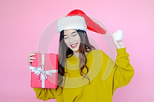 asia woman wearing long sleeve clothes on pink background with gift box in hand, Christmas or X'mas and happy new year