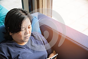 Asia women 40s holding smartphone thinking on sofa