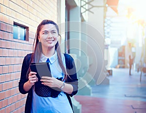 Asia women with tablet is walking in economic zones