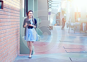 Asia women with tablet is walking in economic zones