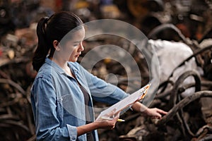 Asia worker woman standing in the automotive engine part at the factory with copy space.  Holding clipboard and checking list