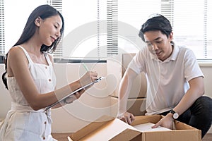 Asia young lovers help packing things in boxes, They prepare to move to a new home.