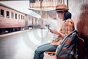 Asia young women tourists sit play smart phone to search for tourist attractions and see the map of travel. at Hua Lamphong