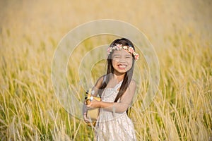Asiagirl playing guitar to meadow outdoor in nature