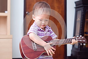 Asian 18 months / 1 year old baby boy child hold & play Hawaiian guitar or ukulele