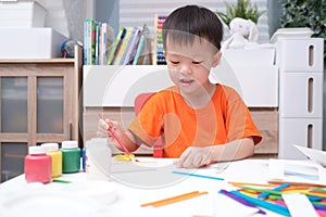 Asian 3 years old toddler boy enjoy using glue doing arts at home, Fun paper and glue crafts for toddlers, Children`s Art Project