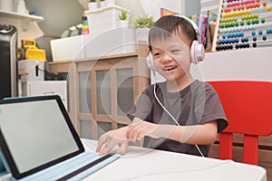 Asian 4 years old toddler boy child using tablet pc computer, Child at home during the Covid-19 health crisis, Distance Learning,