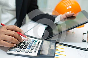 Asian accountant working and analyzing financial reports project accounting with chart graph and calculator in modern office,