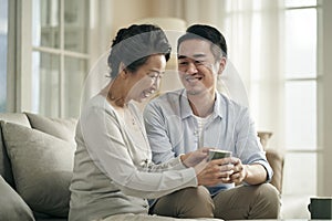 Asian adult son and senior mother having a pleasant conversation at home