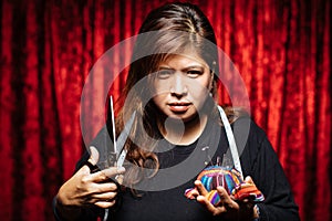 Asian adult woman with scissors at red corner background